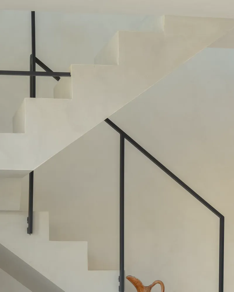 Das schmale schwarze Stahlgeländer der Treppe