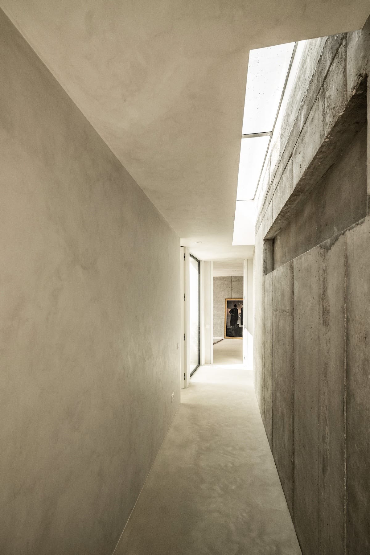 Microcement corridor with natural light at its end
