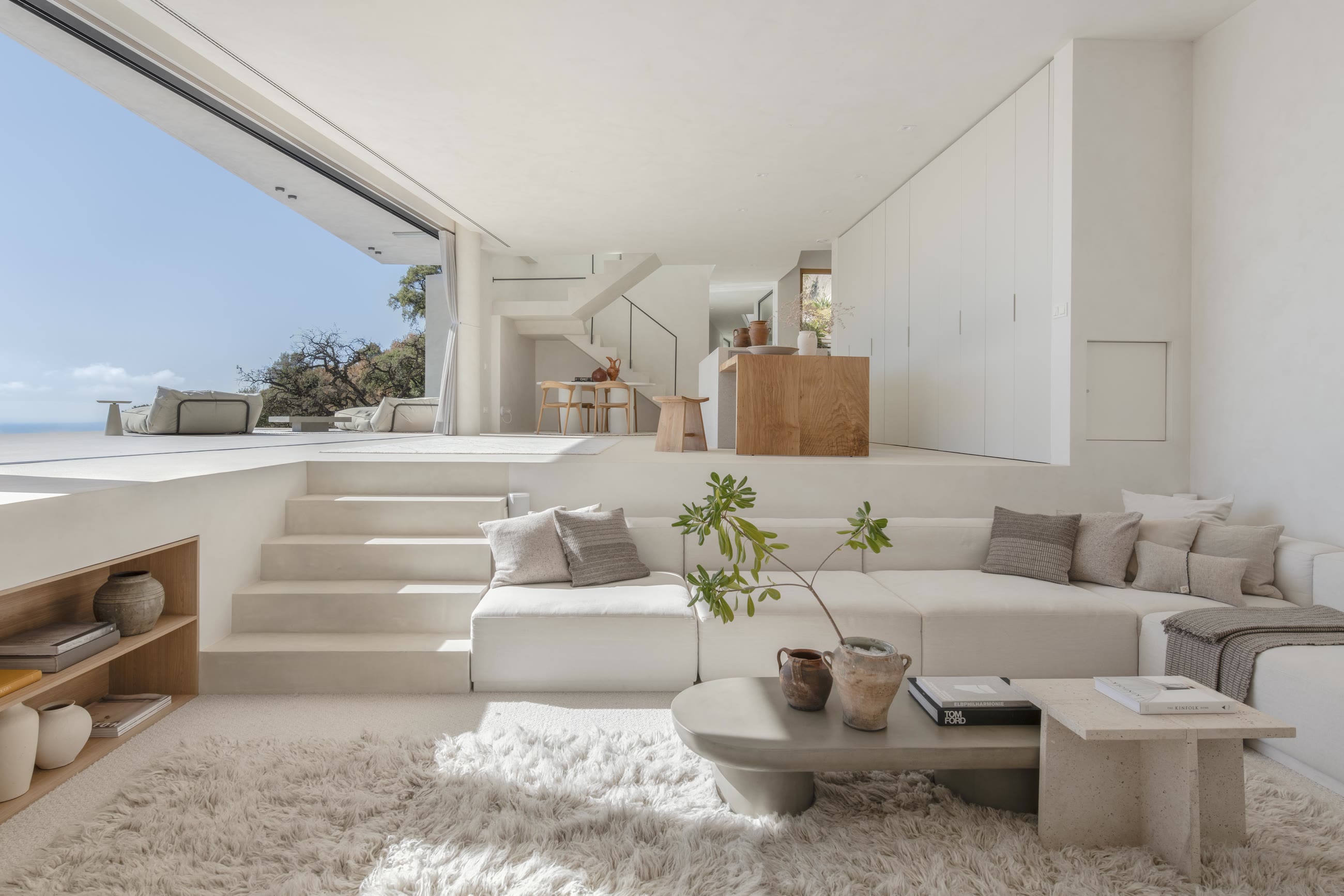 The sunken living room of Casa Jaguar, open through floor-to-ceiling glass to the valley